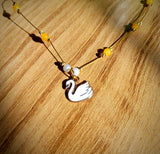 Invisible pendant with yellow bead and swan charm